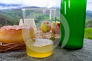 Natural Asturian cider made fromÂ fermented apples and Asturian cow smoked and view Picos de Europa mountains on background